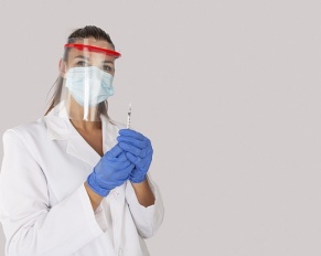 surgeon with face mask and plastic shield