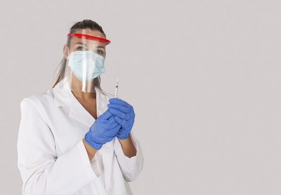 surgeon with face mask and plastic shield